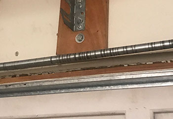 Close-up of a bent and dented lower garage door panel before replacement in Winter Garden, FL.