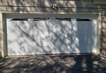 Exterior front view of white double-panel garage door after professional spring installation in Clermont, FL.